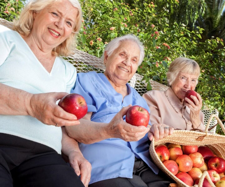 Senior female residents with apples from an apple picking outing