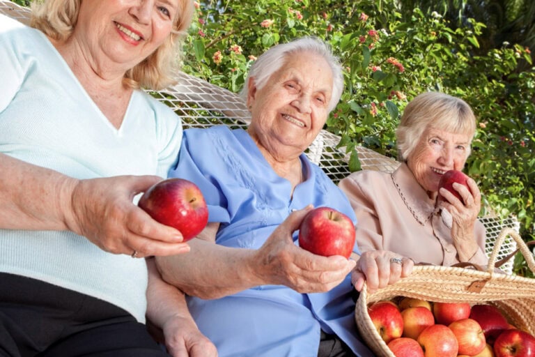 Senior female residents with apples from an apple picking outing
