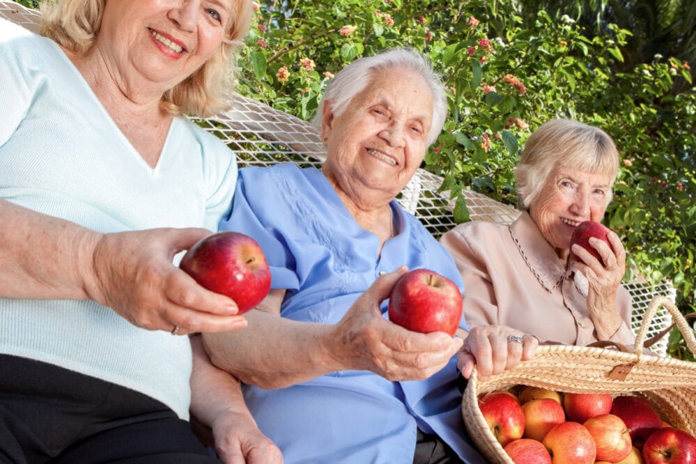 Senior female residents with apples from an apple picking outing