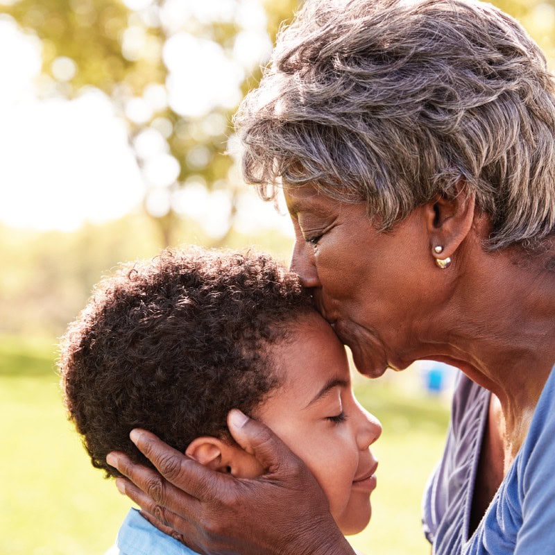 Grandmother kissing the forehead of her grandson