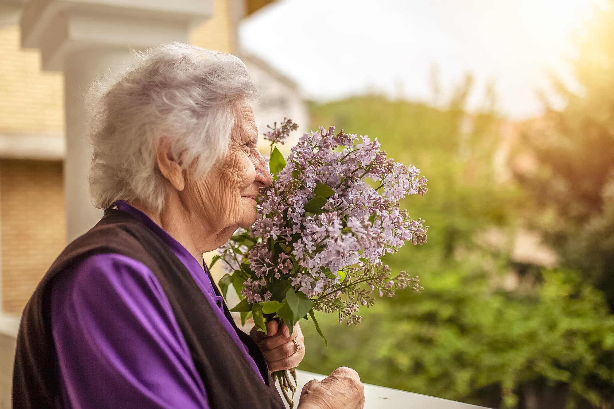 Senior woman with dementia smelling lilacs
