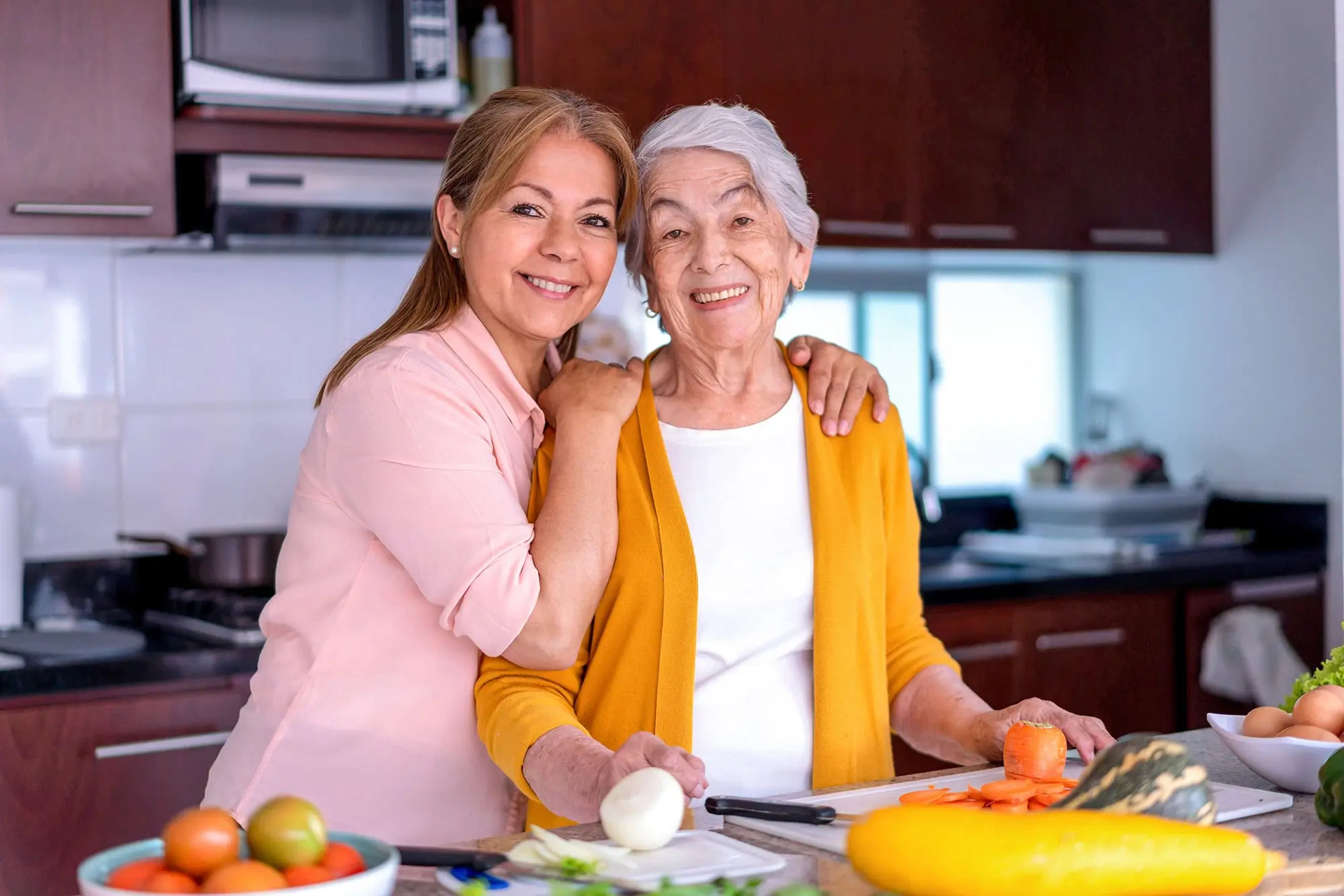 Woman with her senior mother in the kitchen