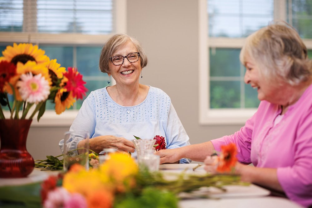 Two female residents arranging flowers together