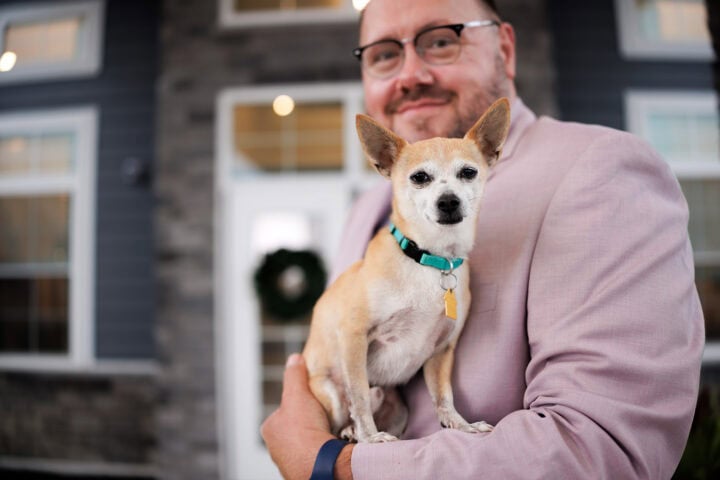 Joseph holding his Chihuahua, Saul at the Pet-friendly Courtyard Entrance