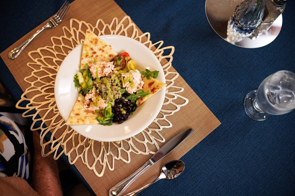 Featured plate setting of salmon salad and flatbread